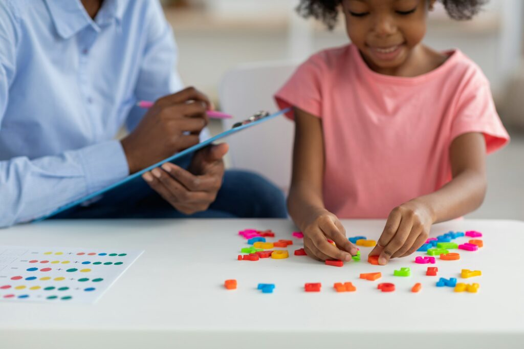 Cute african american child playing with colorful letters